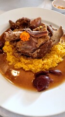 Knuckle of lamb falling off the bone, with sauce and risotto