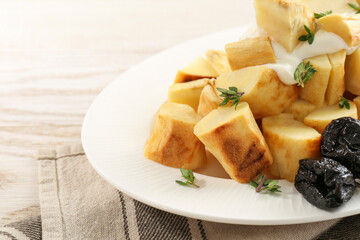 Tasty homemade parsnips with prunes and thyme on white wooden table, closeup. Space for text