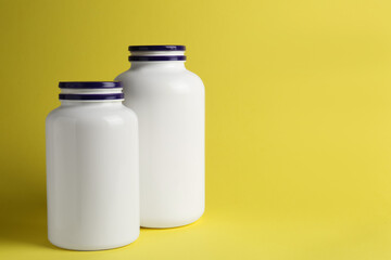 Medicine bottles on yellow background, space for text