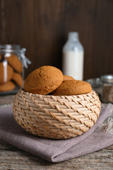 Wicker basket with delicious oatmeal cookies on wooden table