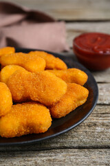 Tasty chicken nuggets on wooden table, closeup