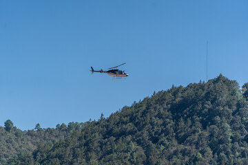 Fototapeta na wymiar The helicopter flies over the mountains.