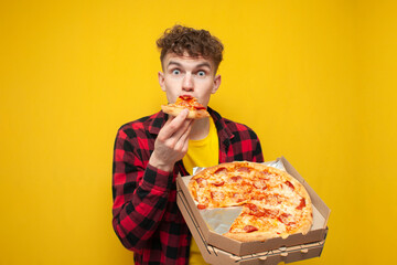 surprised guy eating pizza on yellow background, hungry student enjoying fast food