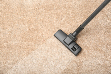 Vacuuming dirty beige carpet. Clean area after using device, top view