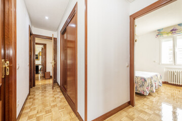 Distributor corridors of a house with French oak wooden floors in slats and sapele wooden doors with matching built-in wardrobes