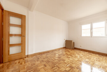 Empty living room of an apartment with a parquet floor made of freshly stabbed and varnished oak...