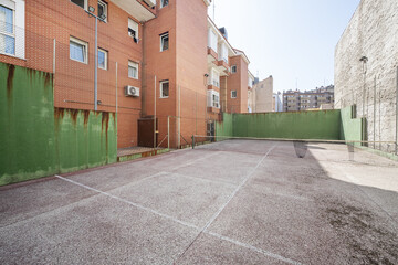 An urban tennis court in a block courtyard between buildings