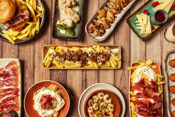 Some wonderful fusion recipes of Italian food and Spanish tapas, pizza with burrata, cheeks stewed in sauce, broken eggs, cured Manchego cheese tapa, garlic prawns, a hamburger and Iberico ham