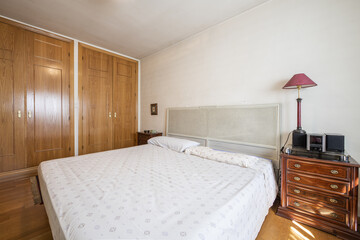 Fototapeta na wymiar Bedroom with wooden beds all the furniture that does not match, wooden floor and fitted wardrobes