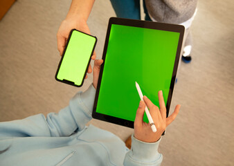 Gadjit top view. Hands holding phone and tablet with styus. Shows the screen.