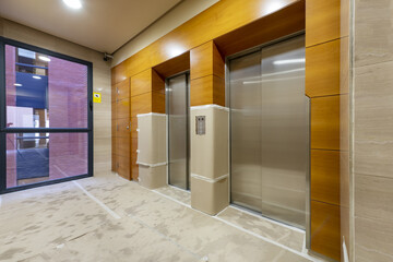 Elevator area of an office building with walls and floors covered with cardboard due to being under construction