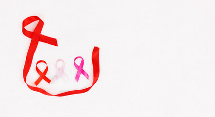 Pink ribbons on white background. Cancer awareness concept, a larger one holds the other smaller...