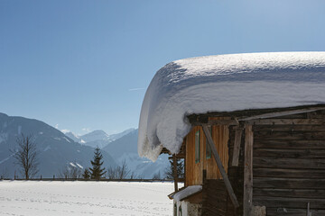 A huge amount of snow on a roof of a house in winter outdoors
