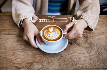 Woman holding a cup of hot latte coffee on the wooden table. morning drink concept