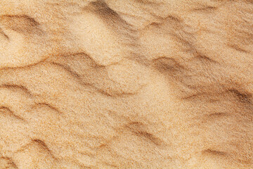 Wavy yellow sand texture closeup background, sandy waves pattern, natural beige sand grains backdrop, rippled dry sand surface top view, light orange desert dune, summer tropical sea beach, copy space