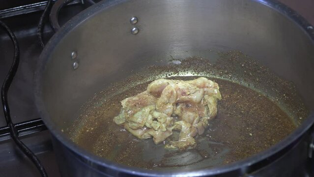 Adding raw chicken to spiced pot