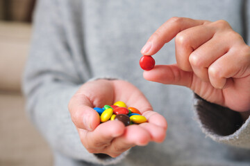 Closeup image of hands holding and picking colorful chocolate candy