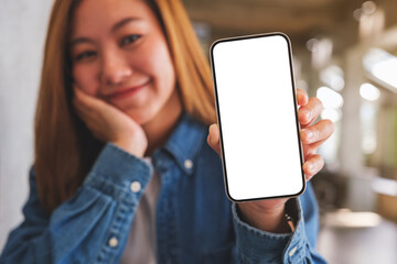 Mockup image of a beautiful young woman showing a mobile phone with blank white screen