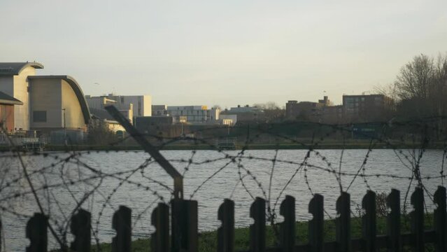 Sun Reflecting Water Reservoir Barbed Wire Fence Buildings