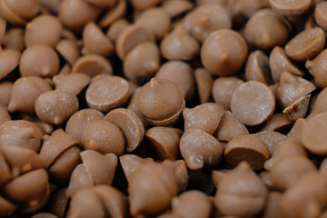 Chocolate chips in white bowl. Measuring cake ingredients. Macro shot