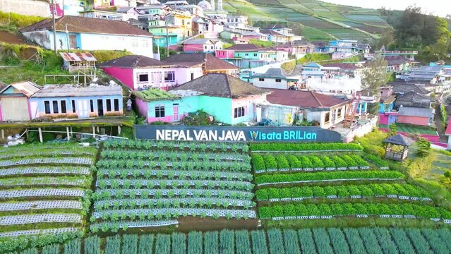 Drone shot of The word "Nepal Van Java" with beautiful village on the slope of mountain. Colorful house of village. Nepal Van Java on the slope of Sumbing Mountain - Indonesia