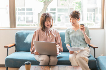 オフィス・カフェでパソコンを使いながらミーティングするビジネスウーマンの女性たち
