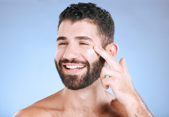 Face, cream and man laughing for beauty, sunscreen product and clean wellness on blue background....