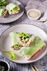 Fresh spring rolls with crab sticks, cucumber and lettuce. Vegetarian food. Vertical view