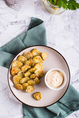 Fried pickles appetizer and sauce in a bowl on a plate. Homemade snack. Top and vertical view