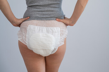 Rear view of a woman in adult diapers. Incontinence problem.