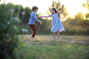 Fototapeta premium Children walk in the summer in nature. Child on a sunny spring morning in the park. Traveling with children.