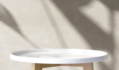 White glossy round side table with wooden leg in sunlight, soft tropical banana leaf shadow on on...