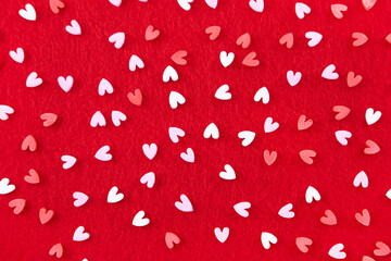 Valentines Day background February 14th. Confetti, red hearts on red background.