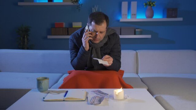 Man talking on the phone complaining about high priced bills.
The low-income man resents high-priced fuel and food bills.

