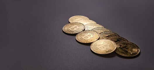 10 physical bitcoin coins on a dark base and background with space to write.