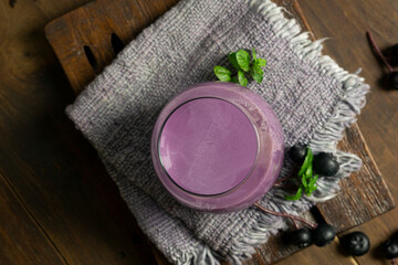Fototapeta na wymiar blueberry-flavored collagen drink with a minimalist photo concept of bright mood and darkmood