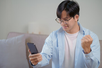 Fototapeta premium Happy Asian man using smartphone and Excited.