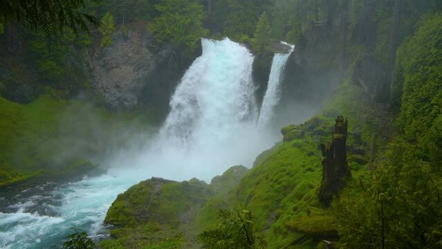Sahalie Falls - A close-up view of Sahalie Falls roaring in green moss-covered misty valley on a stormy Spring morning. McKenzie River, Oregon, USA. 
