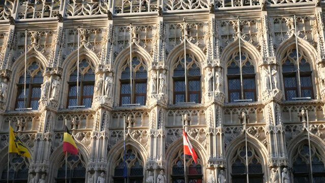 Closeup of lace-like sculptural details and statues on facade of gothic Leuven Town Hall building. Famous Belgian landmark. High quality 4k footage