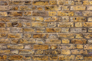 Closeup of part of a wall constructed of yellow London Stock bricks in a pattern of Flemish Bond.