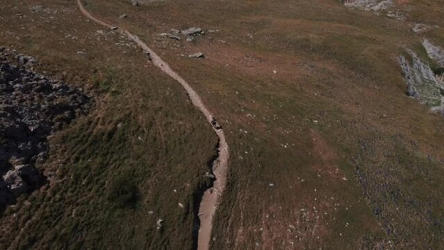 Drone following a woman who practices trail running in the Pyrenees. Running on trails. Running in the mountains. Woman running