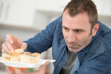 man prepares small dishes for a dinner party