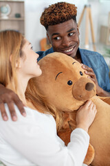 Obraz na płótnie Canvas loving boyfriend giving teddy bear to excited girlfriend