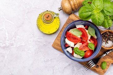 Caprese salad with ripe tomatoes, mozzarella cheese and garden basil