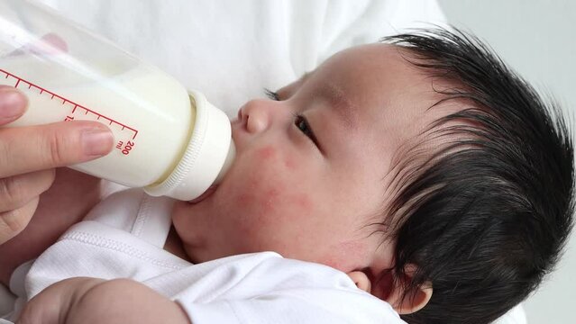母親に抱っこされて寝ながらミルク飲む赤ちゃん（0歳2か月、日本人、男の子）