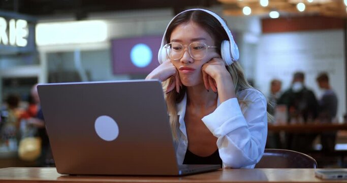 Bored asian young woman student dissatisfied with result of studying at laptop computer, remotely in cafe. Bored asian woman student disappointed with failure in work at laptop computer at modern cafe