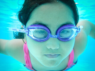 Naklejka premium Young girl swimming under water in summer