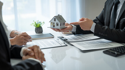 Young Asian home sales agents, insurance agents, and real estate agents offer young Asian entrepreneurs information on price conditions when signing a contract to buy rent house in the office.