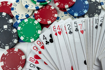 different playing cards and poker chips isolated on white background