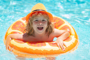 Child splashing in swimming pool. Swim water sport activity on summer vacation with child. Kids water toys.